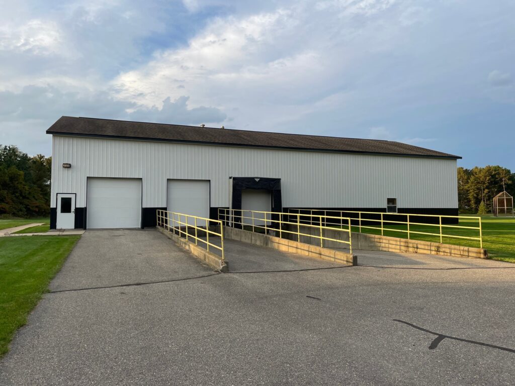 Finished exterior painting on the West Ottawa maintenance barn with white siding on top and black siding on the bottom.