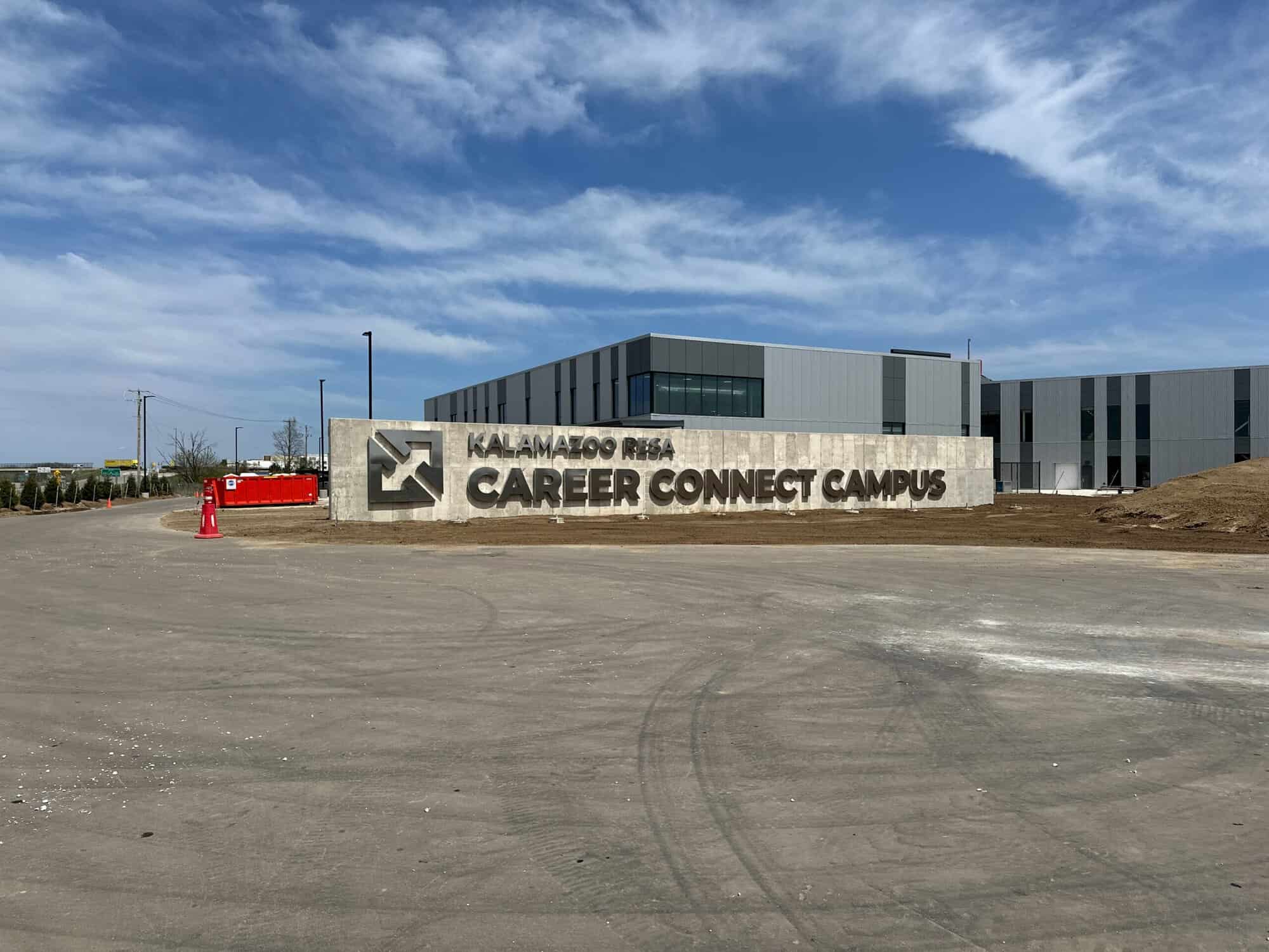 Modern commercial building with gray metal facade and white painted exterior signage reading Kalamazoo RESA Career Connect