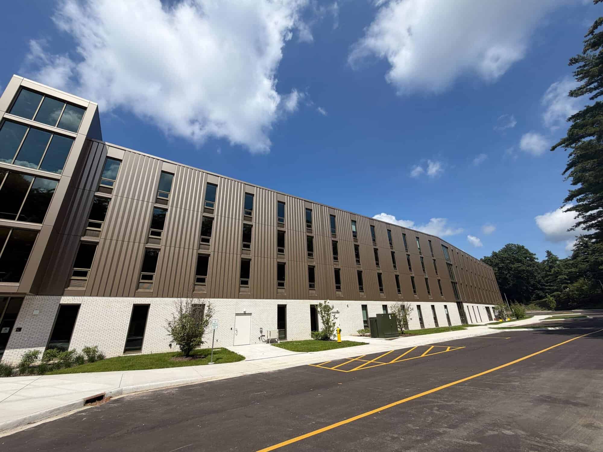 Exterior Commercial Painting Grand Rapids Tan and white painted commercial building exterior with metal ribbed siding and large window openings.